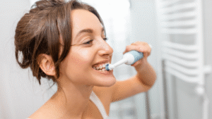 Woman brushing her teeth with an electric toothbrush